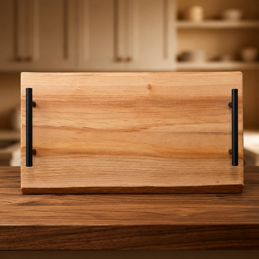 A rectangular wooden serving board or tray made from alder wood  and two black metal handles, shown standing on a wooden table with a softly blurred kitchen background.